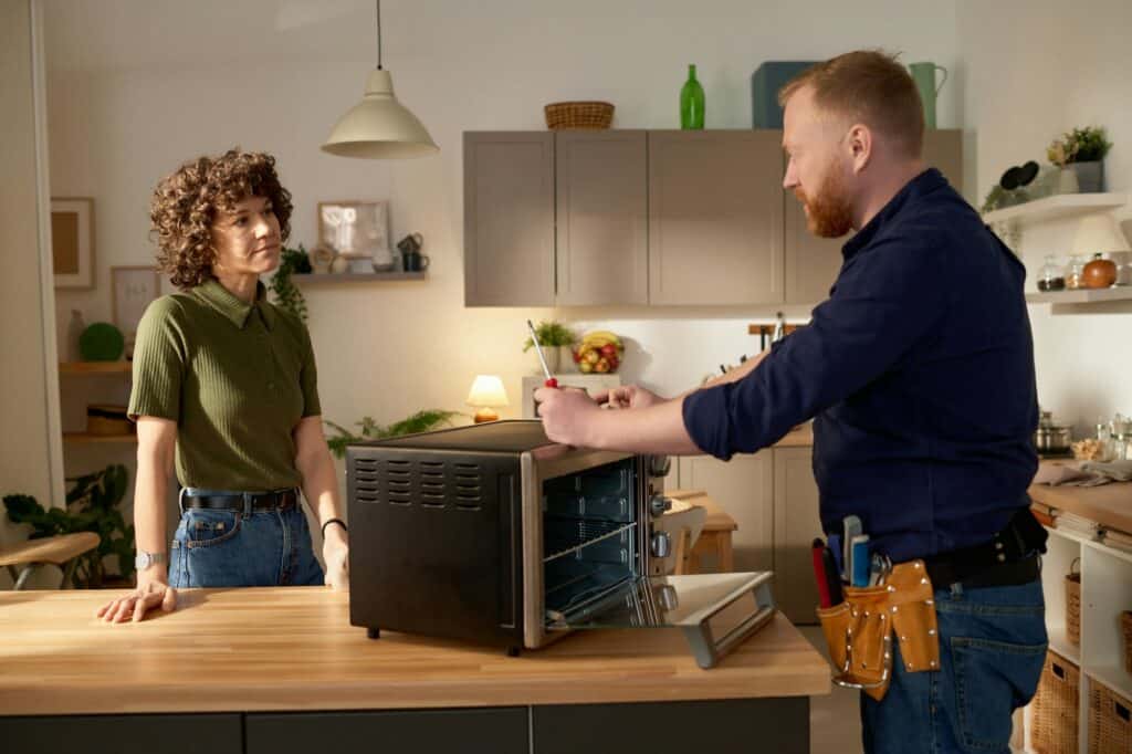 Man repairing broken microwave at home